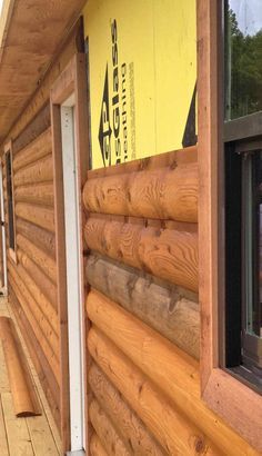 the side of a log cabin with wood siding and window sill on top of it