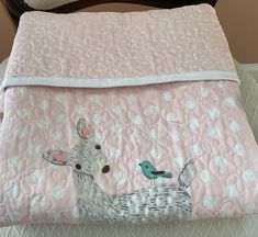 a baby bed with a deer and bird on it