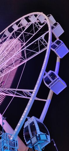 a ferris wheel lit up at night with blue lights on the top and bottom part