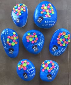 blue painted rocks with colorful balloons on them and the words, adventure is out there