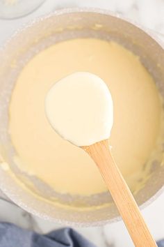 a wooden spoon in a pot filled with batter