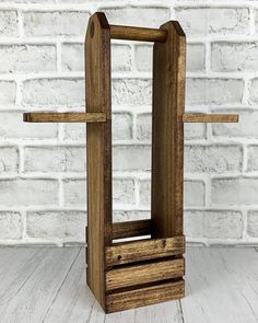 a wooden stand with a cross on it in front of a white brick wall and floor