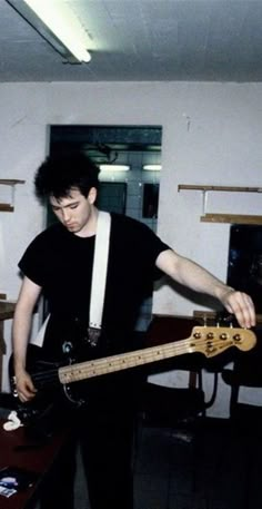 a young man is playing an electric guitar