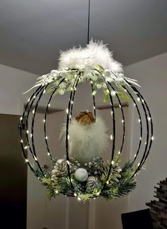 a bird is perched on top of a christmas wreath hanging from a ceiling light fixture