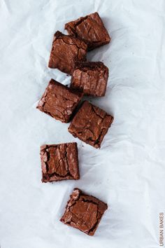 some brownies are sitting on top of white paper