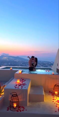 two people are kissing in the hot tub with candles on it at sunset or dawn