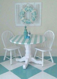 a white table with two chairs and a blue vase