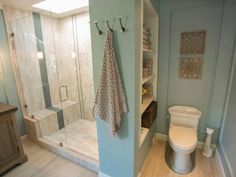 a bathroom with a toilet, shower and shelves on the wall next to each other