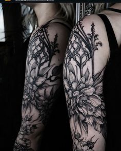 a woman's arm with black and white flowers on it