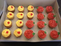 cupcakes with red and yellow frosting are in a box on the table