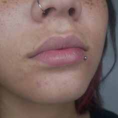 a woman with red hair and piercing on her nose