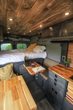 the inside of a camper with two beds and desks in it's center