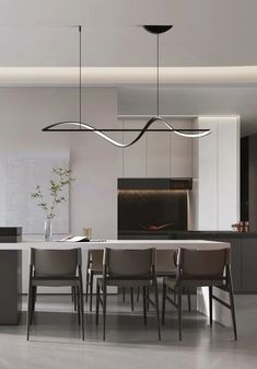 a modern kitchen with an island and dining room table in the center, surrounded by gray chairs