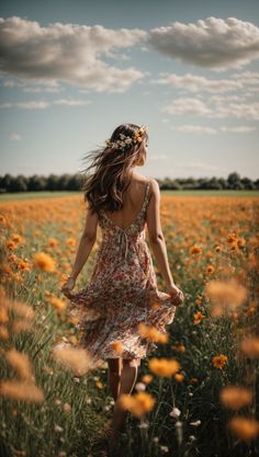 a woman walking through a field full of flowers