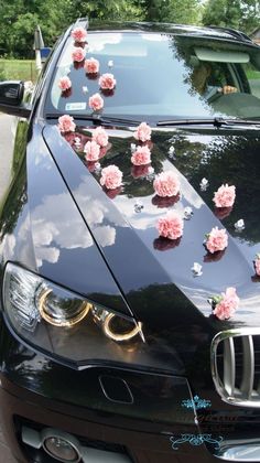 a black car with pink flowers on the hood