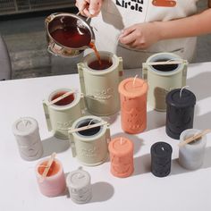 a woman is pouring tea into small containers