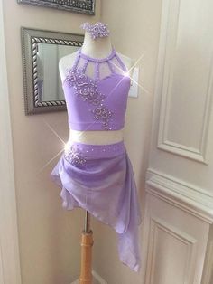 a purple two piece dress on display in front of a mirror