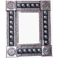 a decorative mirror with an ornate design on the front and back side, in silver