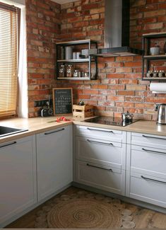 a kitchen with brick walls and white cabinets