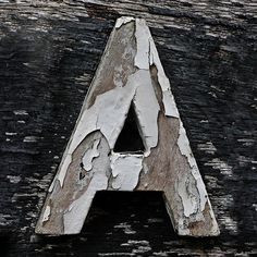 the letter a is made out of wood and has been chipped off with paint