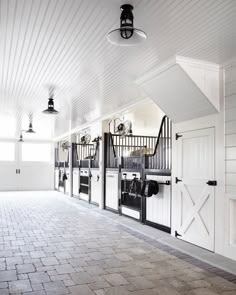 the inside of a horse barn with white walls and doors