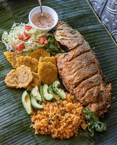 a platter with meat, rice and veggies