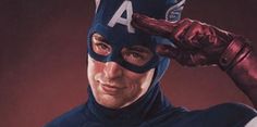 a man in a captain america costume holding his hand up to his head