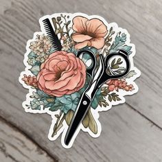 a pair of scissors sitting on top of a wooden table next to a sticker