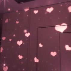 the light is shining on the wall with hearts all over it and stars in the sky