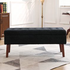 a black bench sitting on top of a white rug