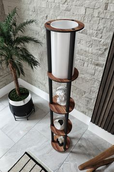 a bathroom with a toilet, plant and towel rack in the corner on the floor