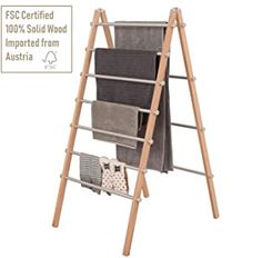 a wooden ladder with several folded towels on it and a sign that says fsc certified 10 % solid wood inspired from australia