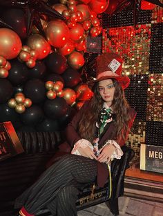 a woman sitting on a chair in front of a wall with red and gold ornaments