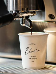 coffee being poured into a cup in front of a espresso machine with the word blauaue written on it