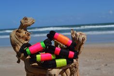 several colorful bracelets on a tree stump at the beach