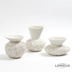 three white vases sitting next to each other