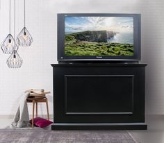 a flat screen tv sitting on top of a black cabinet