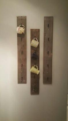 two wooden boards mounted to the wall with purses and bags hanging on them,