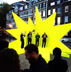 a group of people standing in front of a large yellow star