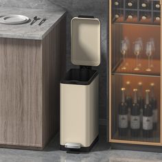 a wine cooler next to a counter with bottles and glasses