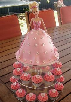 a barbie doll cake with cupcakes in the shape of a dress