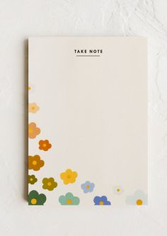 a notepad with flowers on it and the words take note written in black ink