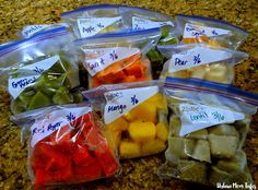 several bags filled with different types of fruits and veggies sitting on top of a counter