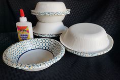 three bowls and two plates are sitting next to each other on a black cloth background