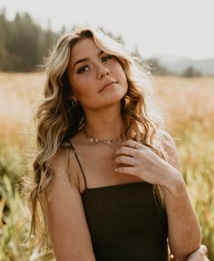 a beautiful blonde woman standing in a field