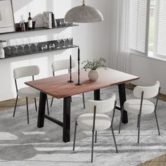 a dining room table with four chairs and a vase