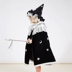 Transform into a witch or wizard with this elegantly creepy costume. It includes a cape and a wand crafted from velvet, tulle and silver lame with silver glitter star and moon details. A fabulous outfit to wear for Halloween, or whenever you fancy casting spells in style! *hat sold separately* The cape is made from black velvet, with chunky silver glitter star and moon details It features a collar crafted from white tulle layers and shiny silver lamé, and embellished with silver glitter stars It Witch Cape, Creepy Costume, Childrens Halloween Costumes, Creepy Costumes, Casting Spells, Cape Costume, Spooky Costumes, Witch Costumes, Velvet Cape