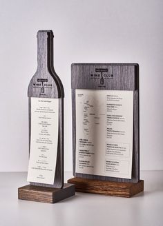 a wine bottle and menu stand on a table