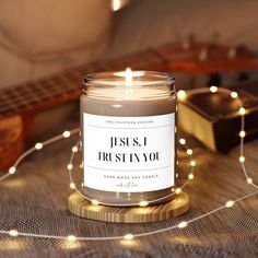 a candle sitting on top of a table next to a string of lights and a guitar