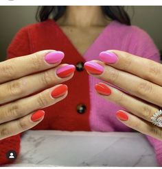 a woman with bright pink and red nail polish on her hands